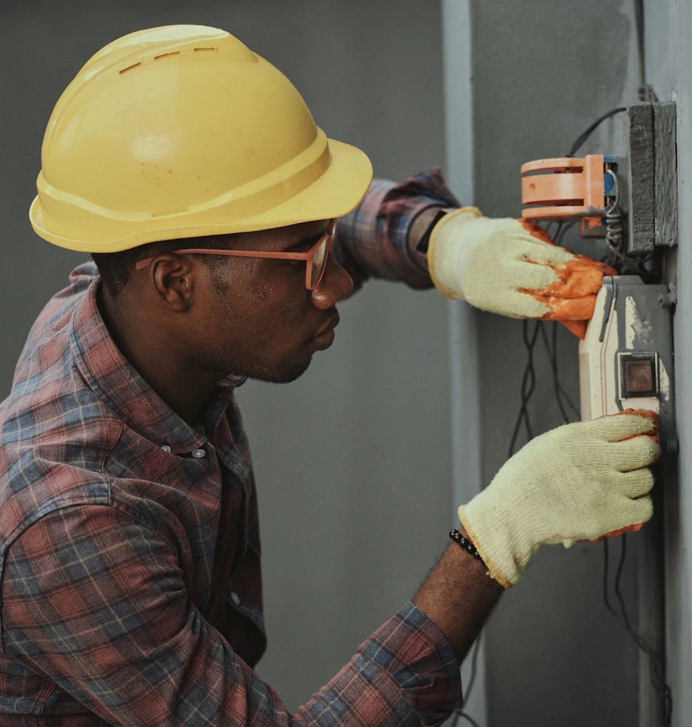 A plumber in a hard hat working on a fixture